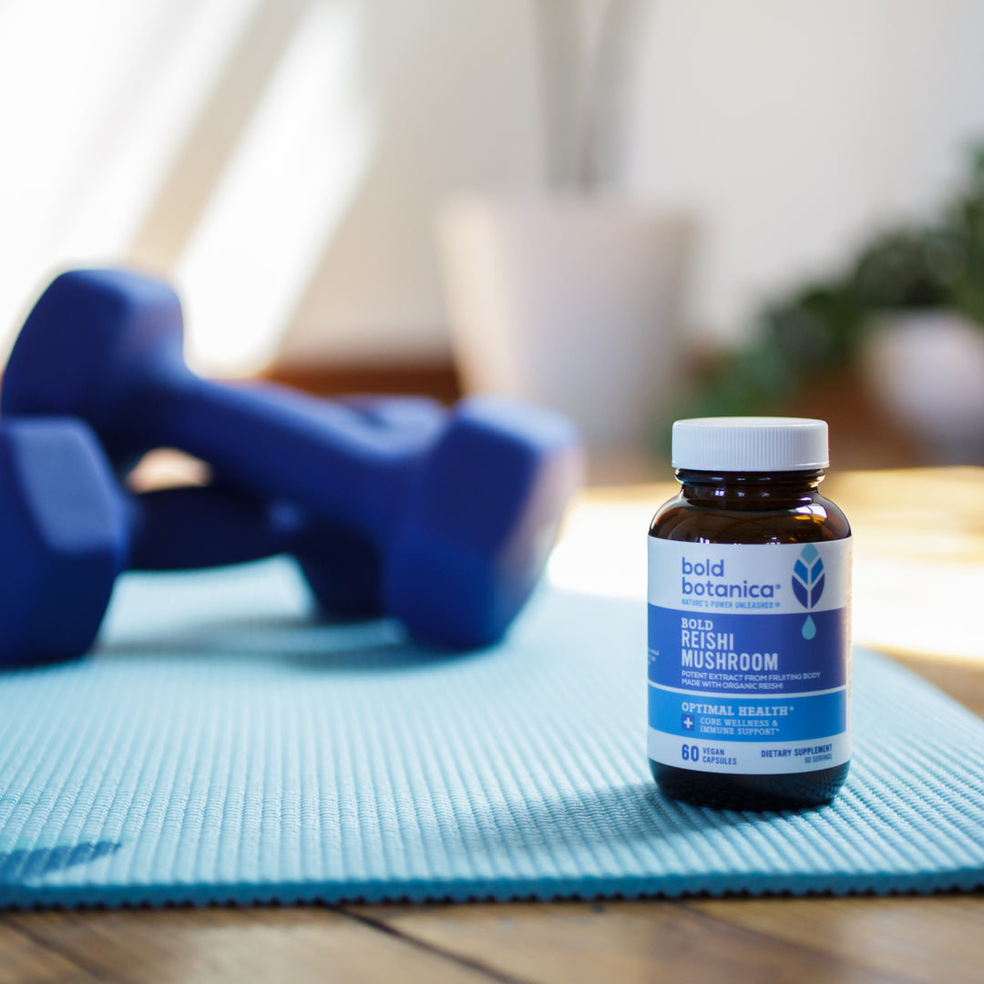 reishi mushroom extract bottle on yoga mat with blue weights