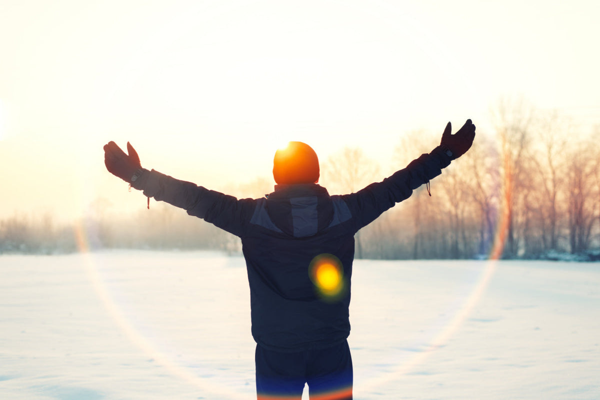 person standing with arms outstretched in the snow