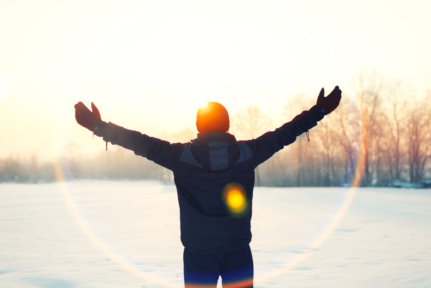 person standing with arms outstretched in the snow