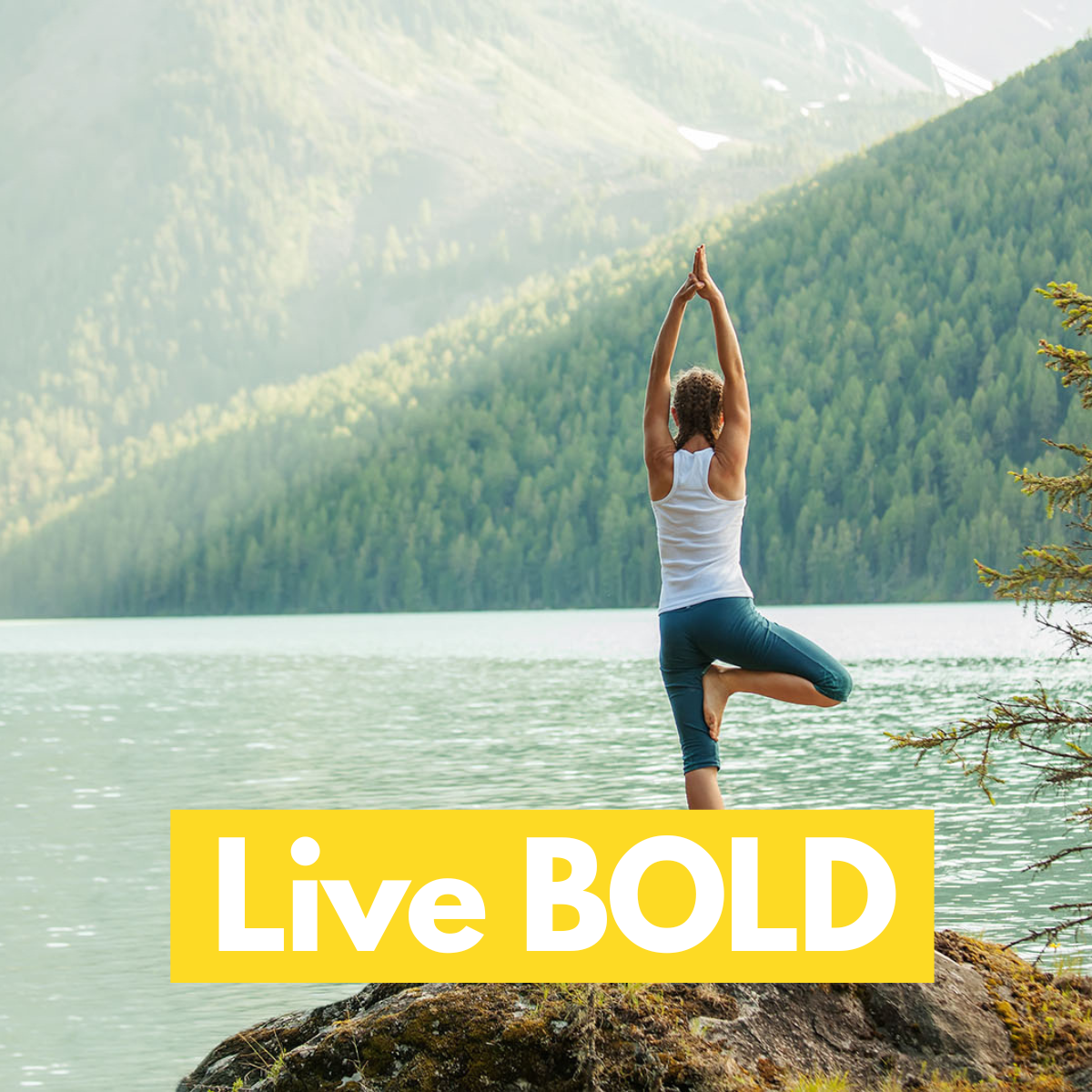 Person practicing yoga by a lake with mountains in the background, featuring the text 'Live BOLD' in bold text in yellow box. 
