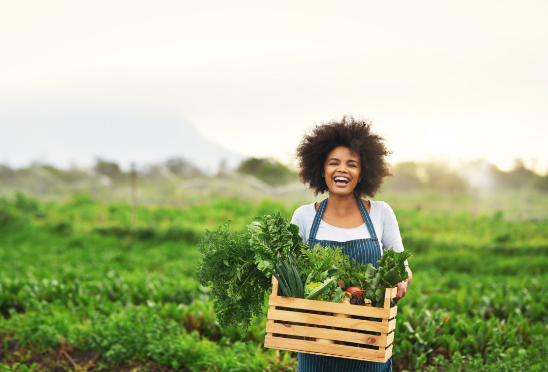 woman holding vegetables in a field