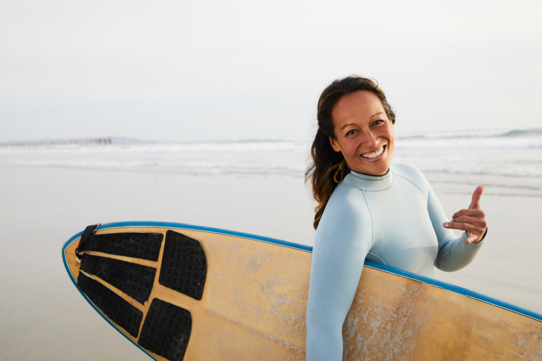 woman surfing with a yellow surfboard