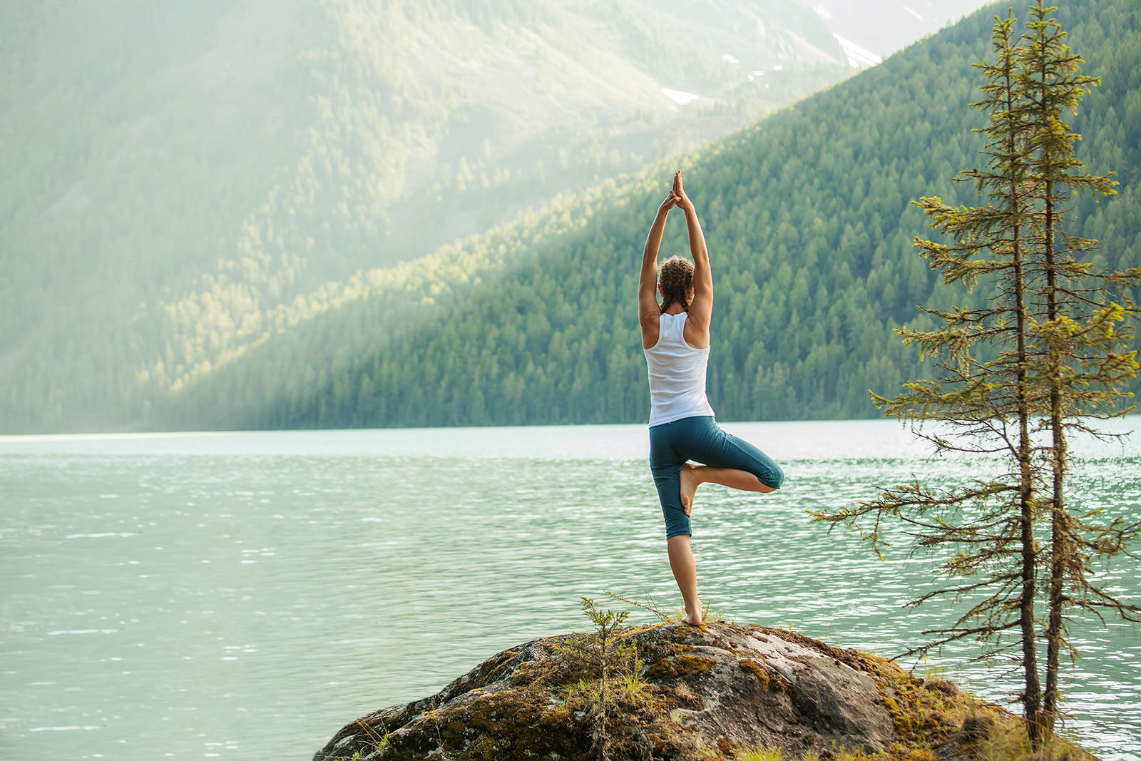 woman doing yoga overlooking a lake